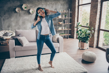 Sticker - Full length photo of beautiful dark skin wavy lady wear modern earflaps singing listening cool songs standing floor near couch casual denim outfit living room indoors