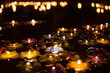 Candle in flower shape lighting and floating on water, Loy Kratong festival at night in Thailand