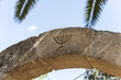 The Israeli symbol - Menorah - carved in stone on an arch at the entrance to the archaeological site of Tel Shilo in Samaria region in Benjamin district, Israel