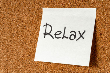Wall Mural - The word Relax on a sticker on a cork board. Background, copy space, design element.