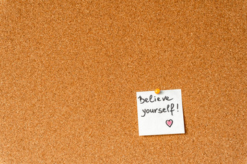 Wall Mural - Believe yourself. Handwritten inspirational supportive lettering on a sticker on a cork board. Background and texture.