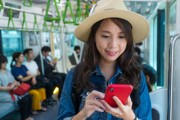 Poster - Woman look at the cellphone inside train car