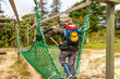 Little boy climbing on the net in adventure park