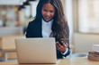© Flamingo Images - Smiling African American businesswoman busy working in an office