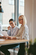 © Flamingo Images - Smiling businesswomen reading paperwork together in an office bo