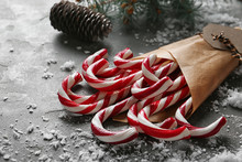 Candy Canes On Grey Table. Traditional Christmas Treat