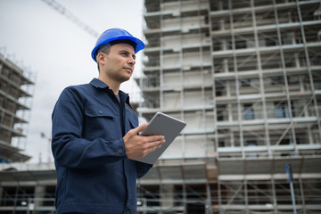 Wall Mural - Site manager using tablet in front of a construction site