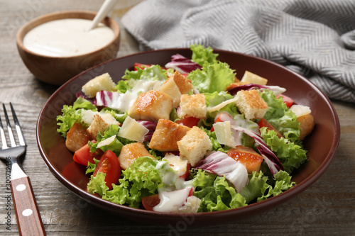 Fotografía Delicious fresh Caesar salad on wooden table