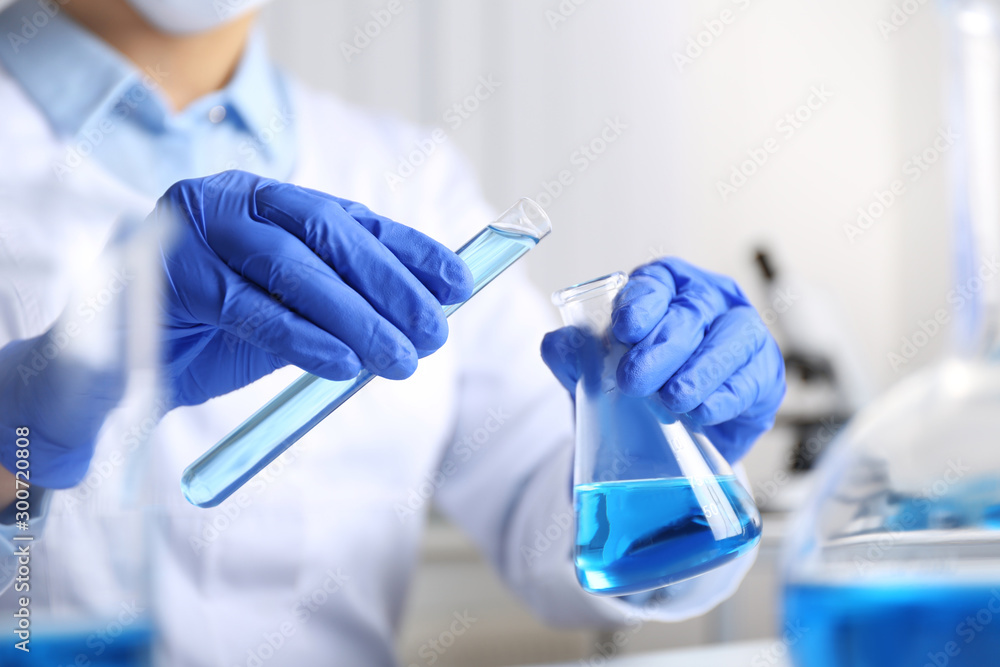 Doctor pouring blue liquid into flask, closeup. Laboratory analysis - obrazy, fototapety, plakaty 