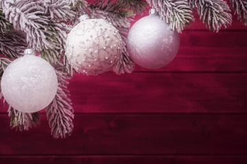 Wall Mural - Christmas balls on spruce frosty brunches against wooden background