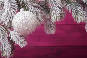 Wall Mural - Christmas ball and spruce frosty brunches against wooden background