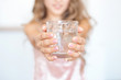 Female hands holding a transparent glass of water. Healthy lifestyle