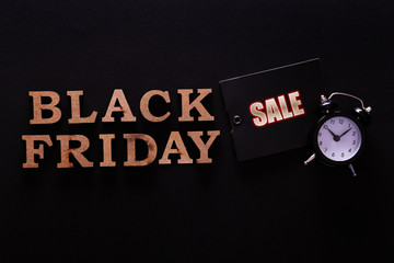 Wall Mural - Black friday sale concept. Fourth Friday of November, beginning of Christmas shopping season since 1952. Old alarm clock, text on paper textured background. Copy space, close up, top view, flat lay