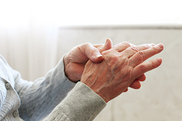 elderly woman applying moisturizing lotion cream on hand palm, easing aches. senior old lady experie