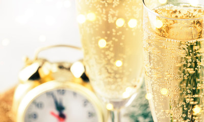 Two champagne glasses and christmas decoration over gray golden bokeh background. Happy New Year Celebration. Selective focus and small depth of field