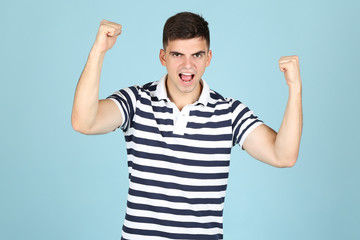 Canvas Print - Young happy man on blue background