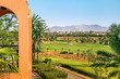 View of Marrakech from a golf resort with green fields and palms in Morocco