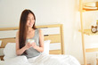 © suchalinee - young woman drink coffee  in bed at the morning