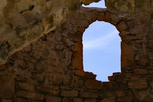 View Of The Sky Through An Arched Window Of An Old Stone Shelter