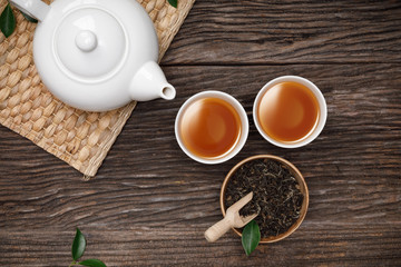 Tea cup with teapot, organic green tea leaves and dried herbs on the wooden desk empty space creative flat lay, Organic product from the nature for healthy with traditional style