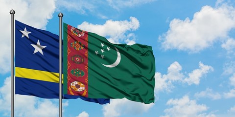 Curacao and Turkmenistan flag waving in the wind against white cloudy blue sky together. Diplomacy concept, international relations.