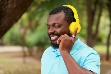 Wall Mural - Handsome African-American man listening to music outdoors