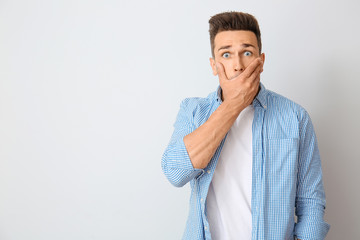 Canvas Print - Surprised young man on light background