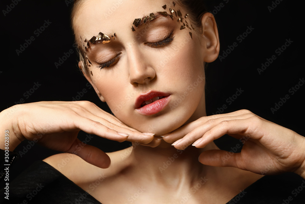 Young woman with creative eyebrows on dark background