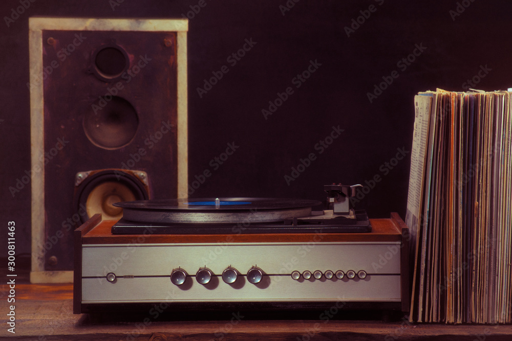 Vintage turntable audio column and vinyl records on a black background. Retro style - obrazy, fototapety, plakaty 