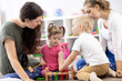 © Oksana Kuzmina - Toddlers and their mothers playing with colorful educational toys in nursery room