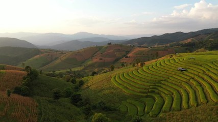 Wall Mural - Aerial View sunlight at twilight of Pa Bong Piang paddy terraced rice fields with farm huts, Mae Chaem, Chiang Mai Thailand