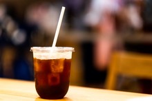 A Black Coffee On Recycle Glass And Paper Straw