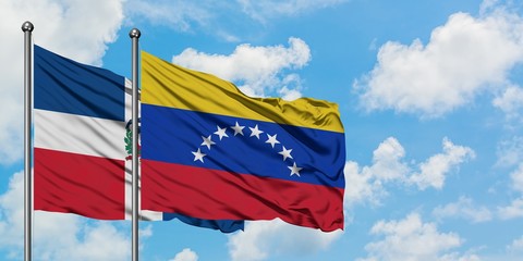 Dominican Republic and Venezuela flag waving in the wind against white cloudy blue sky together. Diplomacy concept, international relations.