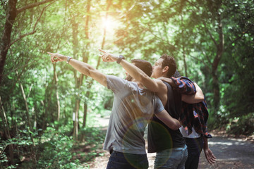 Happy traveler friends hugging and pointing something together at nature,Enjoying backpacking concept