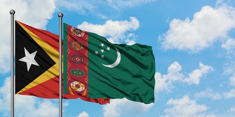 East Timor and Turkmenistan flag waving in the wind against white cloudy blue sky together. Diplomacy concept, international relations.