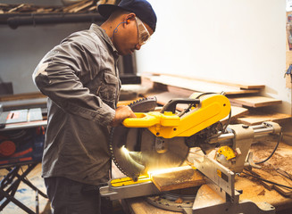 Professional technicians are using saws to cut wood.