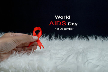 Aids red ribbon on woman's hand support for World aids day and national HIV/AIDS and aging awareness month concept