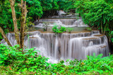 Fototapeta Łazienka - Travel to the beautiful waterfall in tropical rain forest, soft water of the stream in the natural park at Kanchanaburi, Thailand.