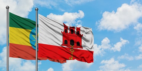 Ethiopia and Gibraltar flag waving in the wind against white cloudy blue sky together. Diplomacy concept, international relations.