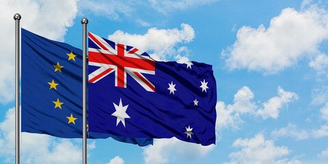 European Union and Australia flag waving in the wind against white cloudy blue sky together. Diplomacy concept, international relations.