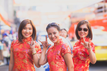 group of asian woman wearing chinese tradition clothes toothy smiling face happiness emotion and hand sign i love you