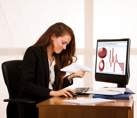 Angry business woman expressing rage at her desk in the office