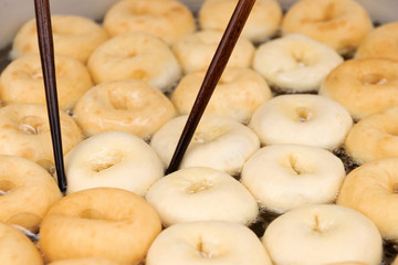 Wall Mural - Deep frying doughnuts in hot oil. Made of fresh ingredients tasty.