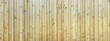 Panorama einer unbehandelten, leicht verwitterten, braunen Holzwand mit aufgesetzten Latten 