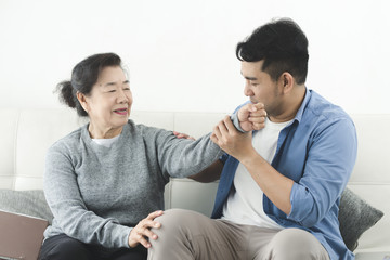 Wall Mural - Asian man massage his mother at home, lifestyle concept.