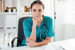 © JustLife - Young female doctor in medical office. Portrait of beautiful female doctor sitting in the clinic office.