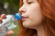 © lokisurina - pure drinking water, young red-haired girl with a bottle of water, bottled water