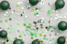 Abstract Glittered Christmas Background With Green Baubles Over White Board. Copy Space.