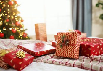 Wall Mural - christmas gifts on bed near christmas tree in morning in bedroom .