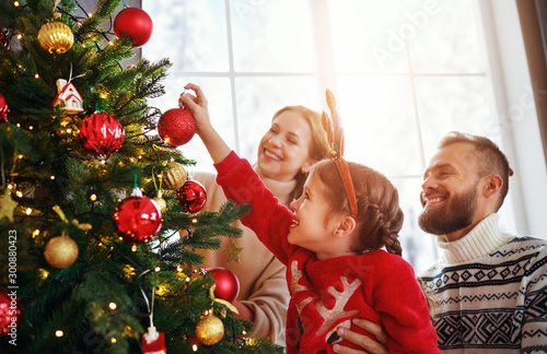 Fotografía happy family mother, father and child daughter decorate Christmas tree
